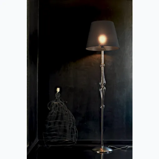 Lampada da terra Miss con struttura cromata,  stelo sagomato in pirex trasparente e paralume in tessuto di Le Fablier