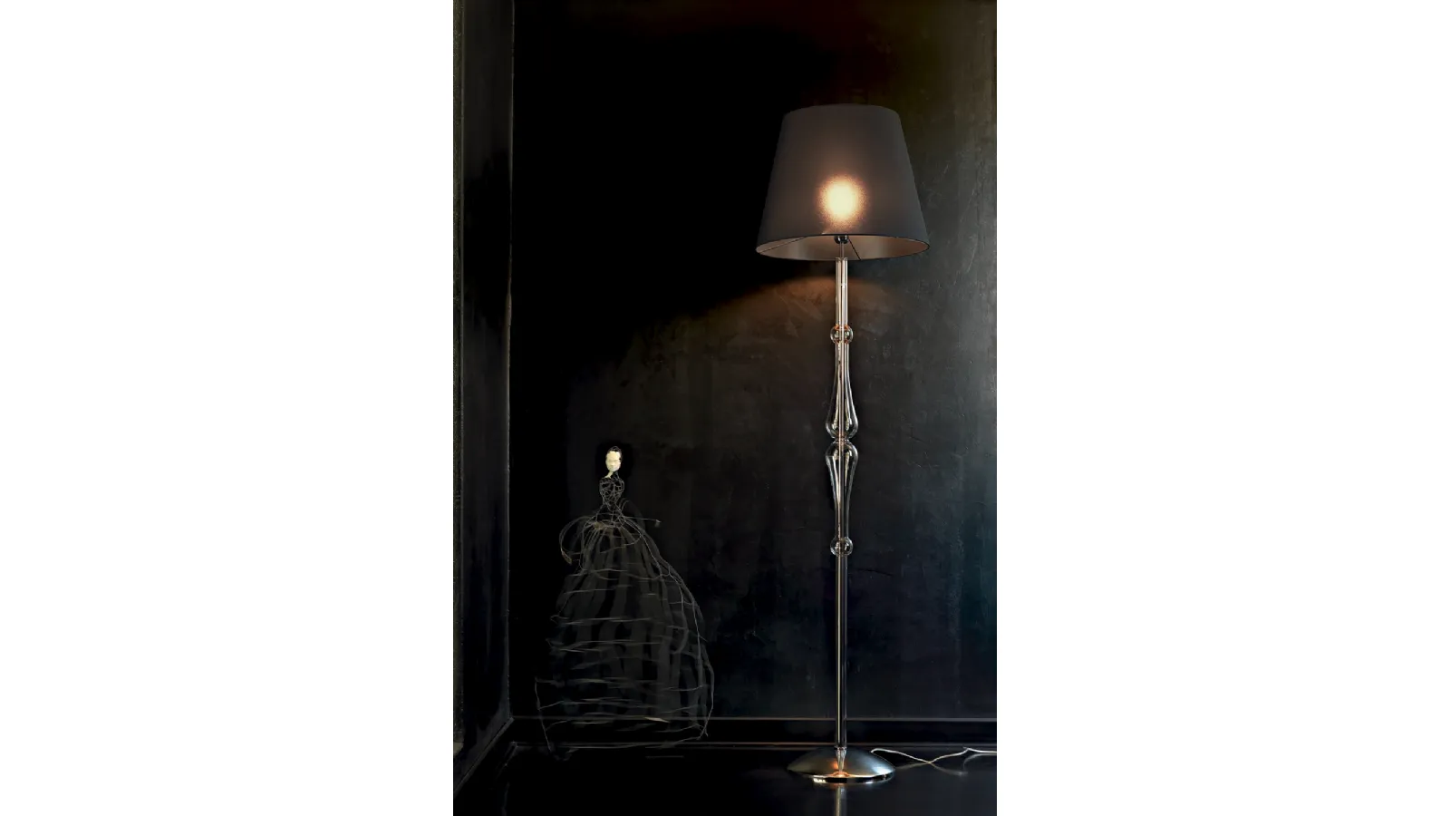 Lampada da terra Miss con struttura cromata,  stelo sagomato in pirex trasparente e paralume in tessuto di Le Fablier