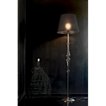 Lampada da terra Miss con struttura cromata,  stelo sagomato in pirex trasparente e paralume in tessuto di Le Fablier